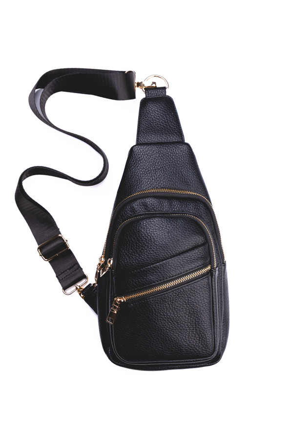Black leather sling bag with gold zippers on a white background